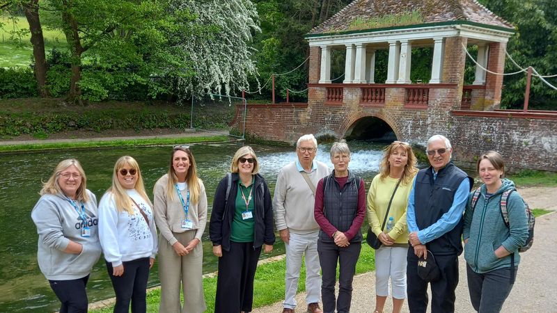 Group of walk leaders by a river with bridge in background