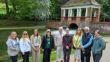 Group of walk leaders by a river with bridge in background