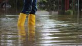 Person in yellow wellington boots standing in flood water