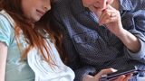 Child shows older person something on a mobile phone