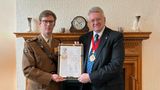 Chairman of Kent County Council Gary Cooke receives a framed certificate from Lt Col Nathan Horsmann showing KCC's gold award as a military friendly employer
