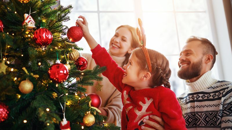 Man and woman with a girl at a Christmas tree