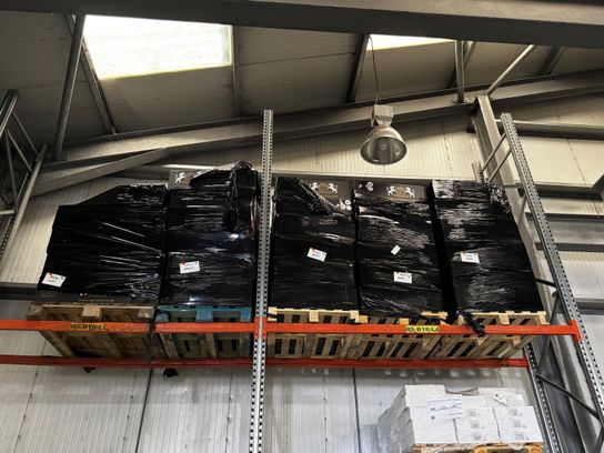 Showing some pallets wrapped in black plastic on shelving in a warehouse