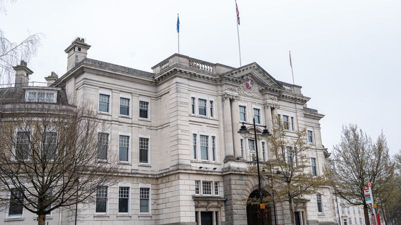 A landscape image of the front of Sessions House with the flag poles on top.