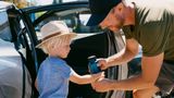 Dad giving water to young son in the hot heat of the day