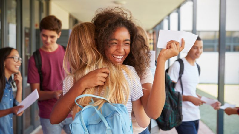 Image of young people hugging after getting exam results