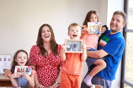 Happy family with adopted children showing family photos