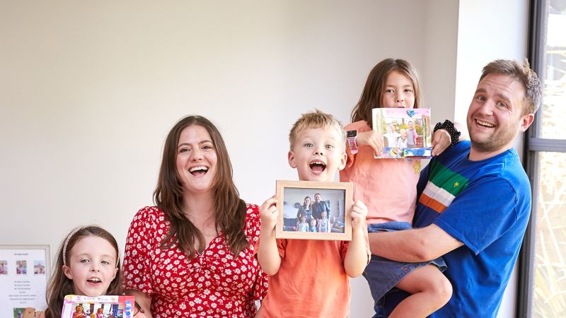 Happy family with adopted children showing family photos