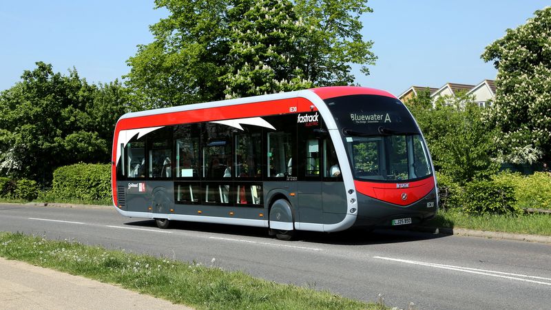 A photo of a red bus on a road.