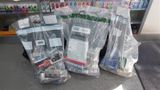 Three evidence bags full of illicit cigarettes sitting in front of shelves of similar products on a shop floor