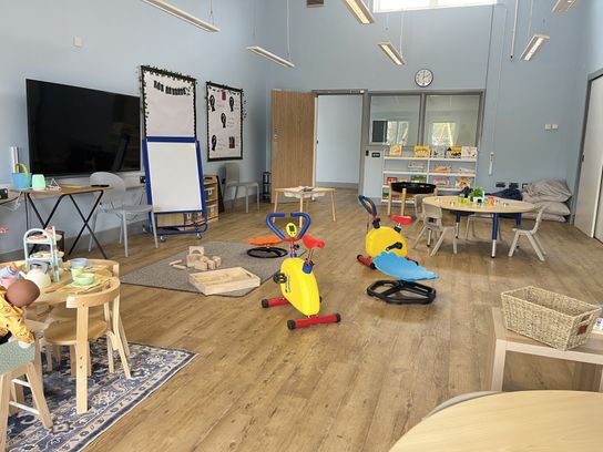 A classroom with lots of toys and a table with a tea set on it