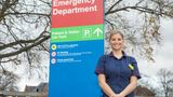 Nurse standing outside by hospital sign
