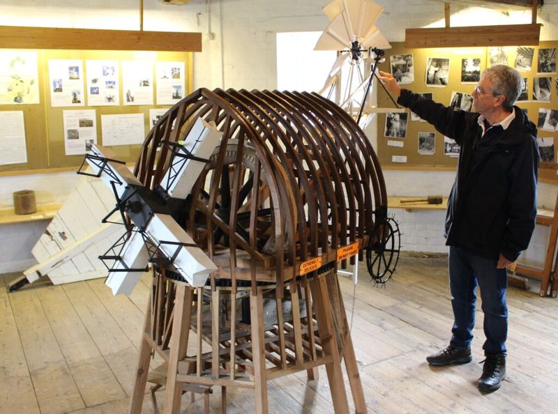 Volunteer Ian Burrows demonstrates the workings of the of the windmill Cap linking the force of the wind to the turning of the millstones using a 1/25th scale model.