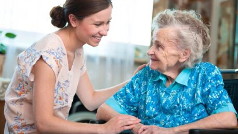 Care worker helping elderly lady