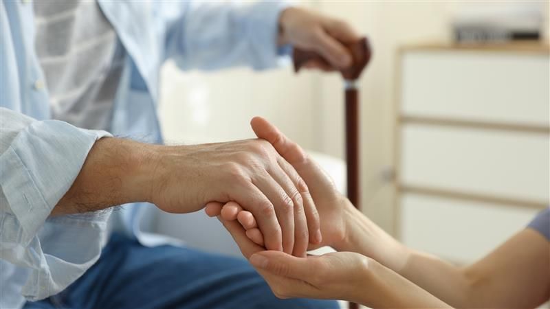 Young carer taking eldery persons hand