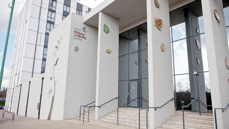 An exterior landscape photo of the glass doors at the Kent History and library centre. entrance