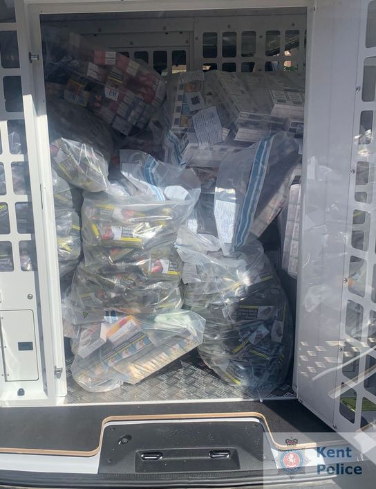 The open back of a police van showing seized tobacco in evidence bags