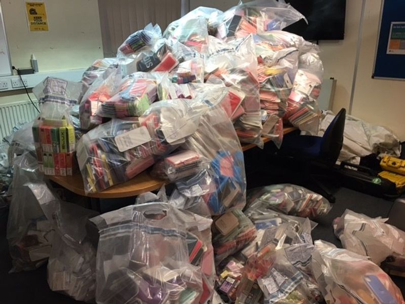 A pile of plastic bags full of seized illegal vapes