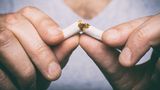 Man's hand snaps a cigarette in two