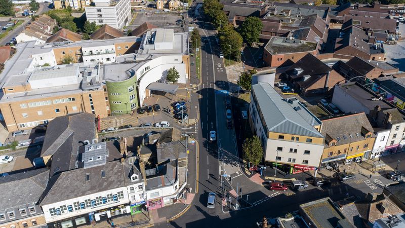 A drone image of roads and buildings from above and a river at the top of the photo.