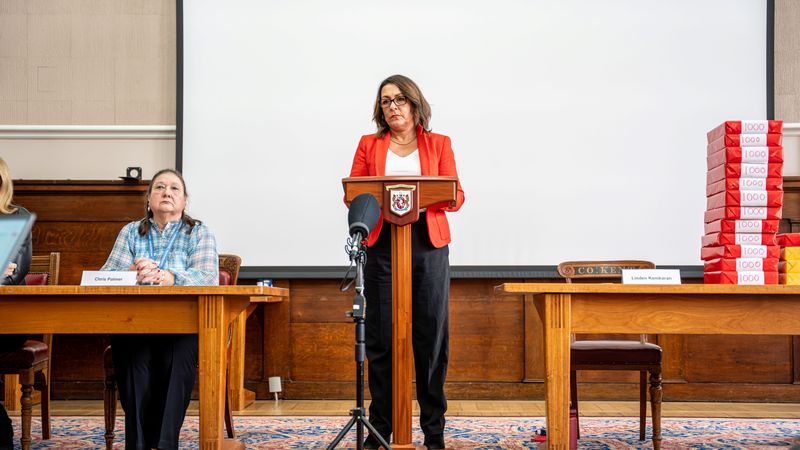 Limden Kemkaran stands at a podium addressing the media
