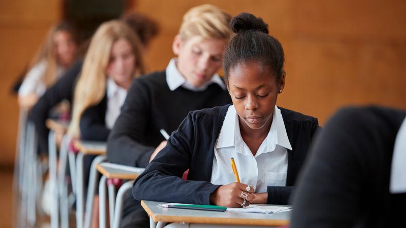 Teenage girls and boys in unifom taking exams