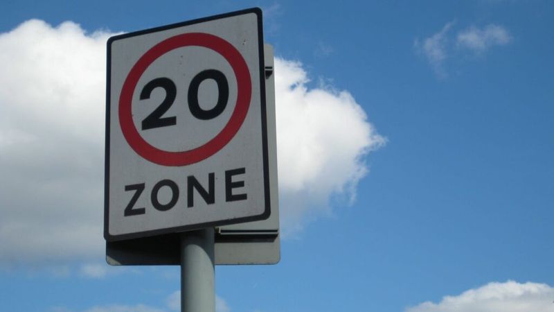 A 20mph zone sign shown infront of blue sky.
