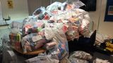 A large number of rubbish bin bags filled with illegally seized vapes on a desk in an office.