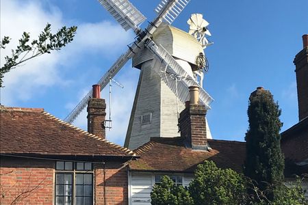 A windmill with buildings in the foreground