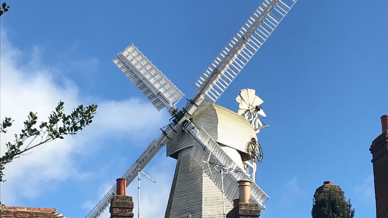 A windmill with buildings in the foreground