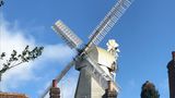 A windmill with buildings in the foreground
