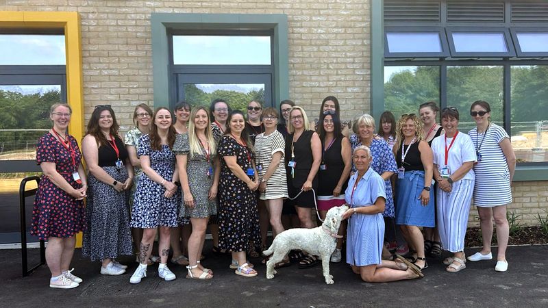 A group of teachers smiling standing outside the new building at Teynham Parochial Church of England Primary School