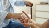 Carer holding elderly person's hand