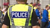 The back of a Policeman showing a high vis uniform showing "POLICE"