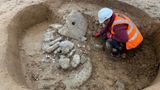 Excavation of a large Roman pit containing millstones