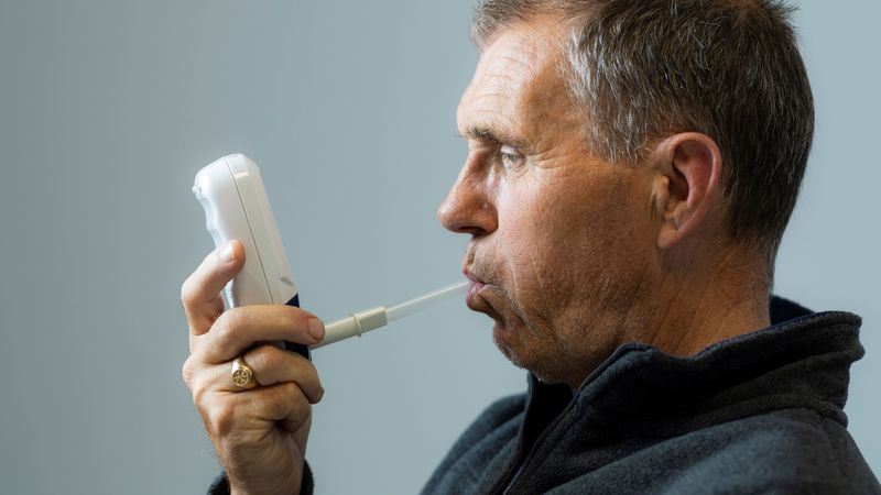 David Kerr measures his lung capacity with a spirometer