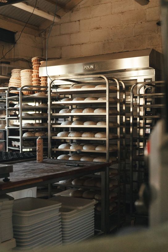 Inside the Gilda bakery showing the shelves of loaves waiting to go into the industrial ovens