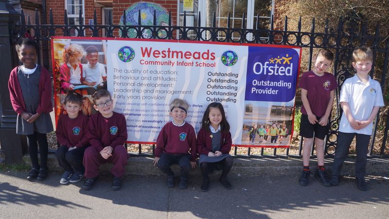 Pupils from Westmeads Community Infant School standing outside the school celebrating their 'outstanding' Ofsted rating