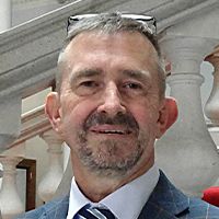 David Wimble is smiling for his headshot photo in front of the county hall steps