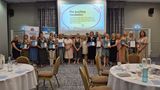 A group photo of teachers smiling and holding their Scheme for Schools and Settings accreditation certificates