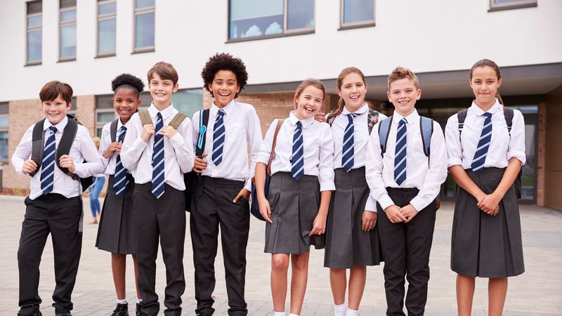 Children in uniform outside primary school