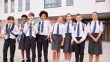 Children in uniform outside primary school