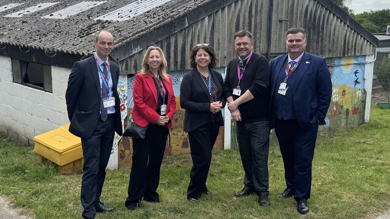 Staff from Homewood School and members of Kent County Council stand outside one of the buildings on the school's farm
