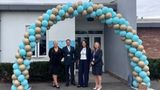 4 people standing in front of a balloon arch