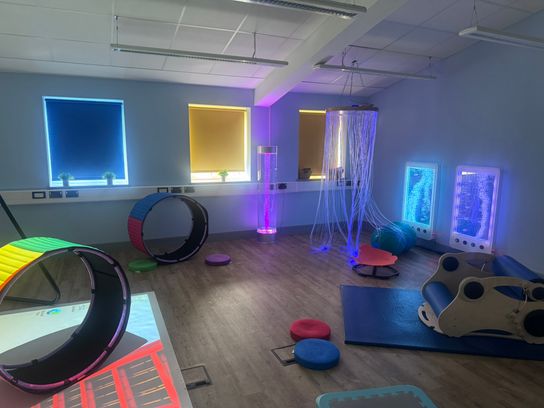 A sensory room with lots of lights and sensory equipment