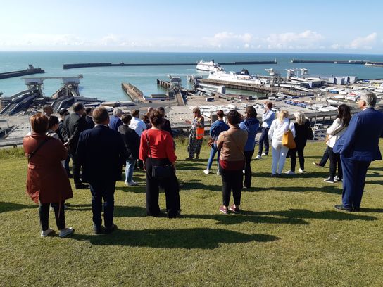 The Straits Commitee, made up of representatives from KCC and authorities in Essex, France, Belgium and the Netherlands, visits Dover and are standing on the white cliffs overlooking the port with the ferry berths beyond, being briefed on plans to create the world’s first decarbonised high-volume shipping corridor