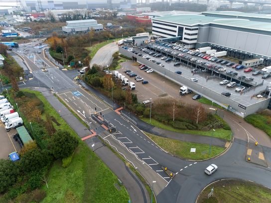 An aerial view of the new Rennie Drive. The image shows a road with a warehouse to the right and lots of cars. 