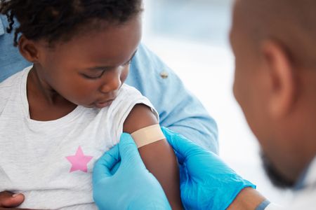 Doctor puts plaster on young child's arm