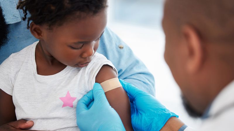 Doctor puts plaster on young child's arm