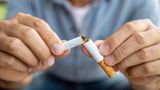A pair of hands hold a snapped cigarette 
